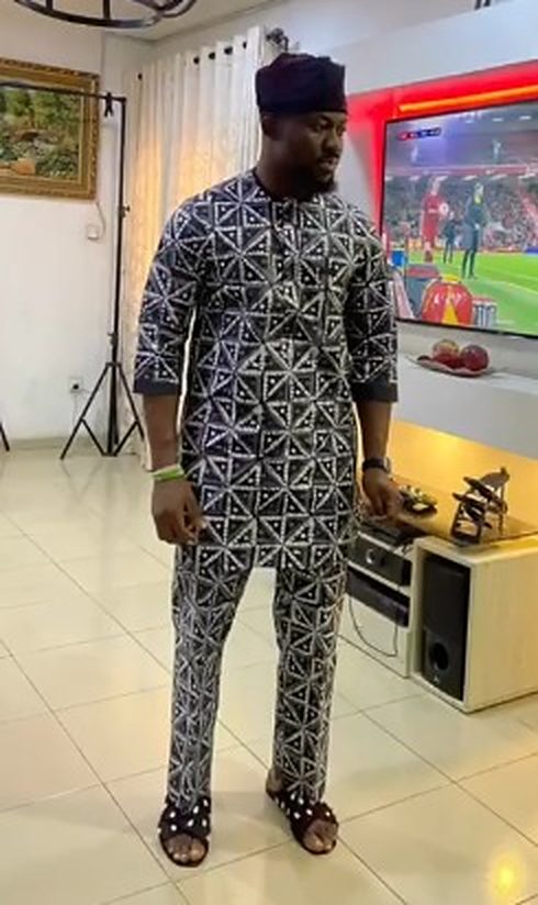 Man in an indigo and white adire-style diamond-print buba and trousers with a matching cap