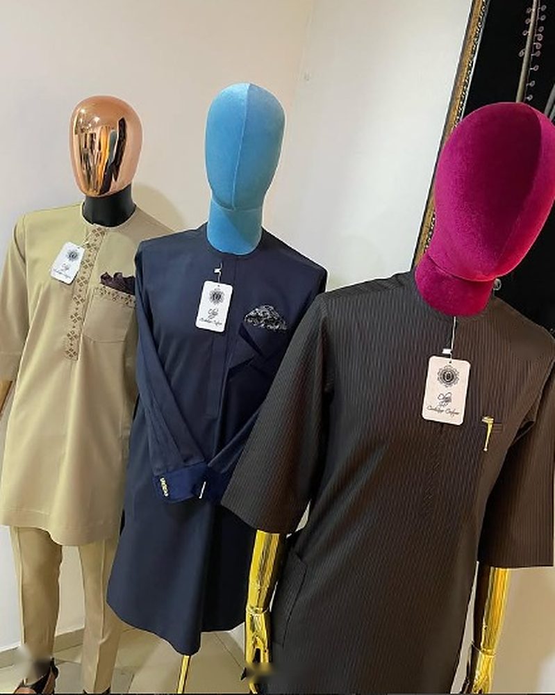 Three senator outfits on mannequins in khaki with embroidery, navy with pocket square, and charcoal pinstripe